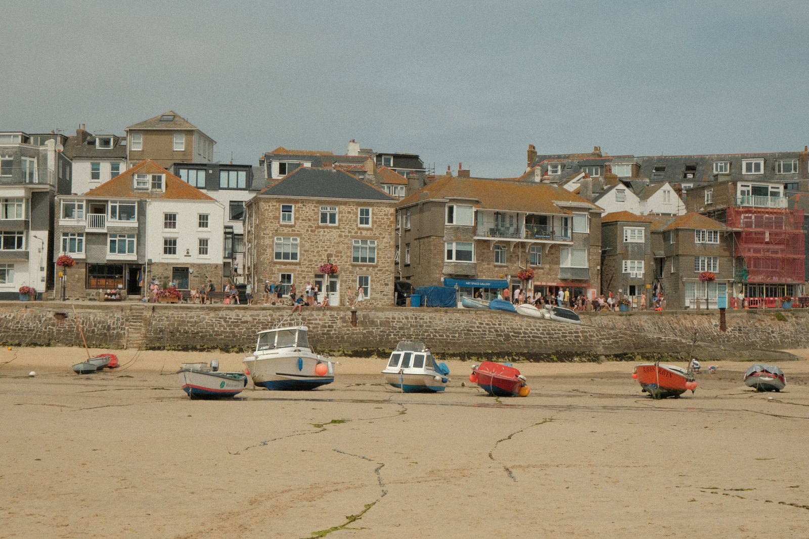 Fishing boats on the sand below waterfront houses in St Ives, England